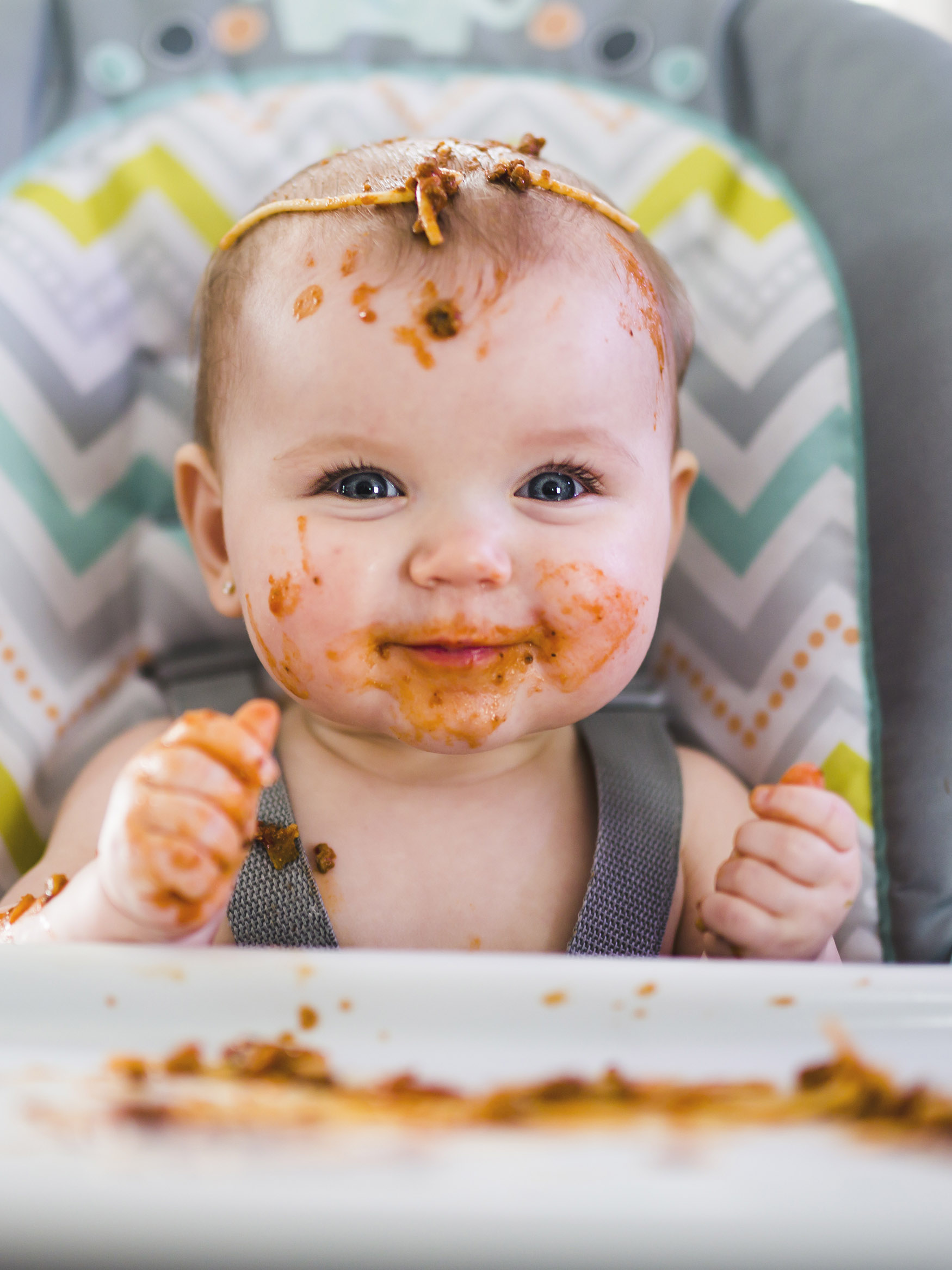 Little baby eating her dinner and making a mess