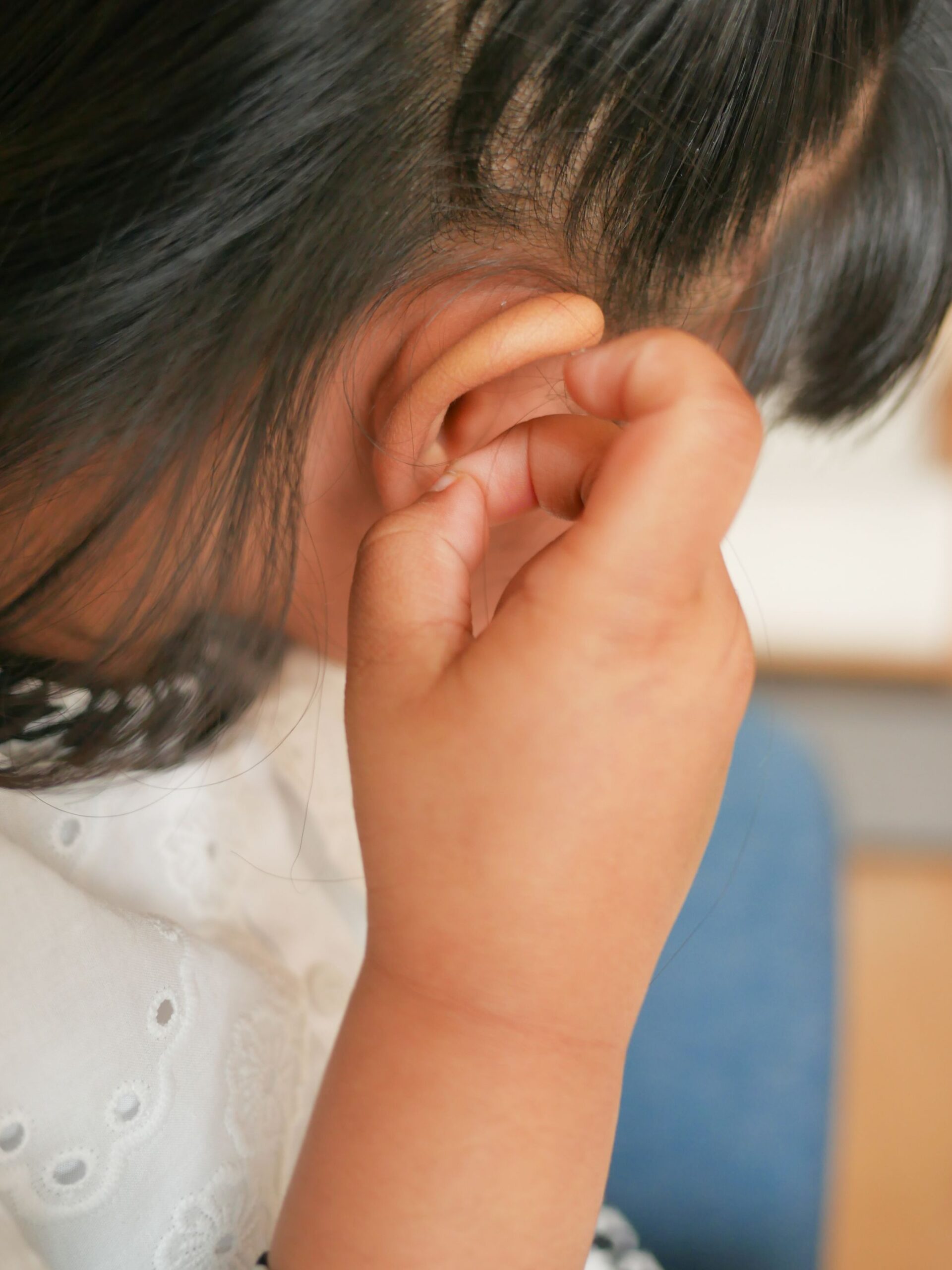 toddler girl touches painful ear